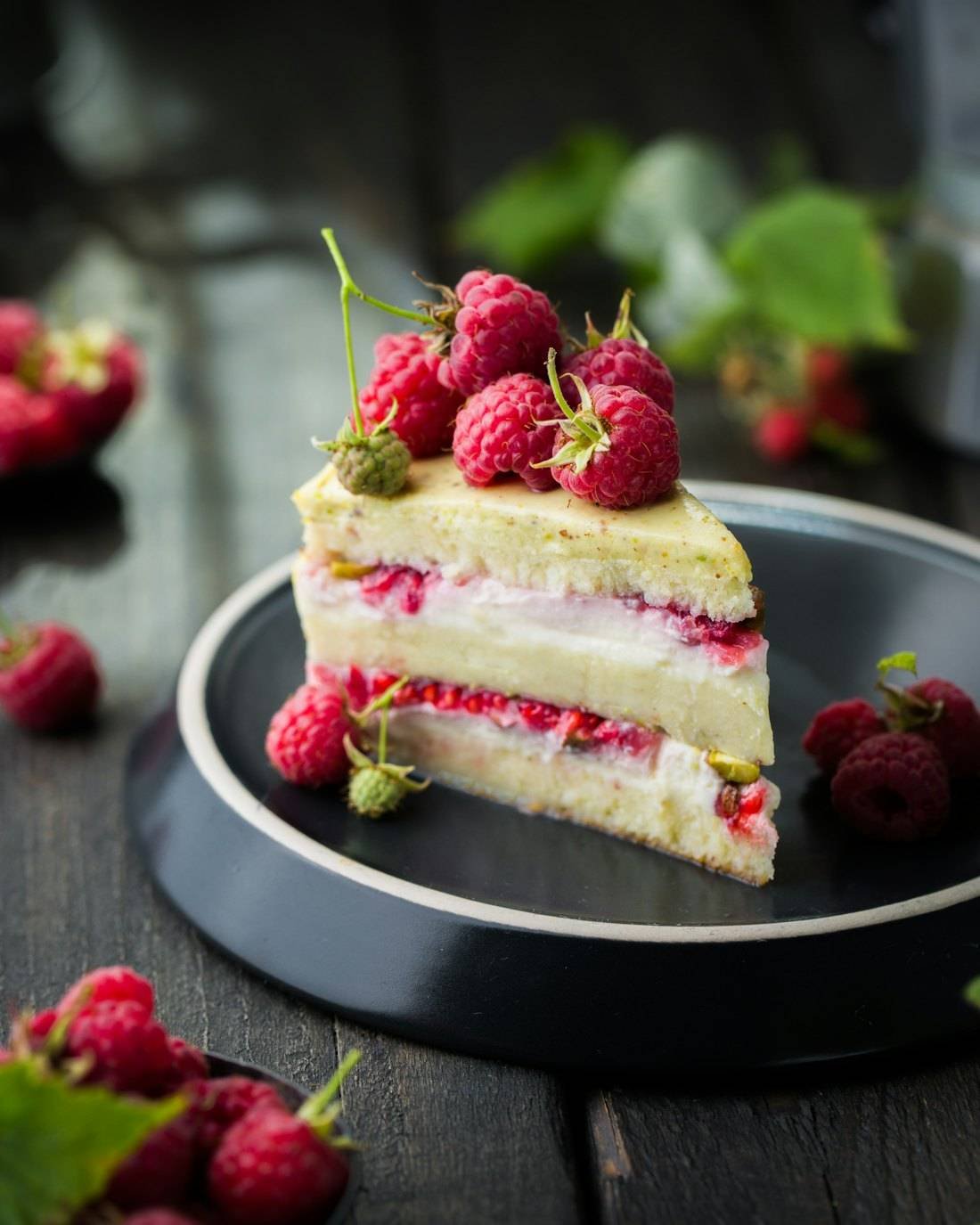 Slice of raspberry cream cake on a dark plate