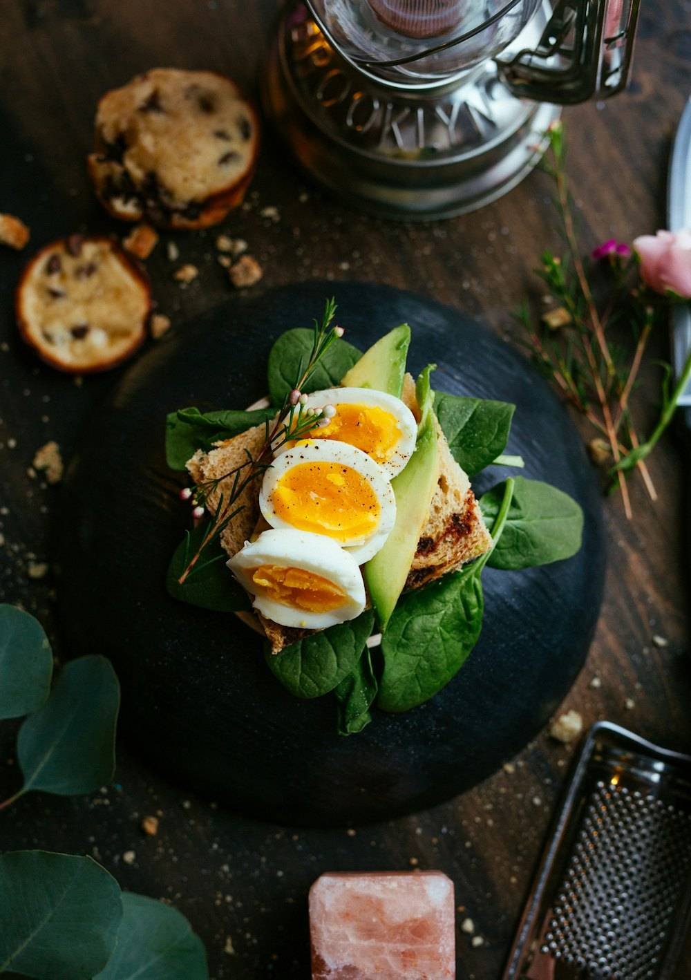 Avocado and soft egg toast with greens on a dark plate