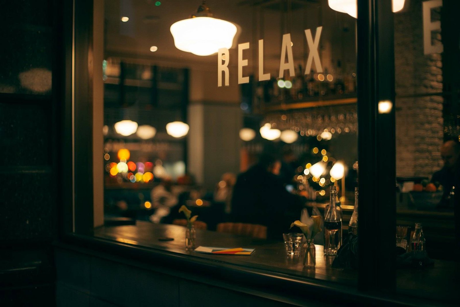 Warm café windows glowing at dusk from the street