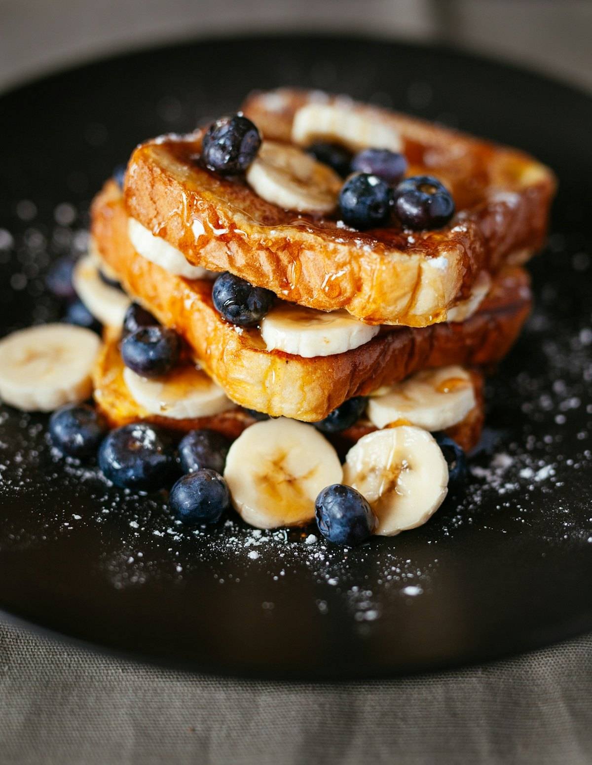 Cinnamon french toast stacked with bananas and blueberries